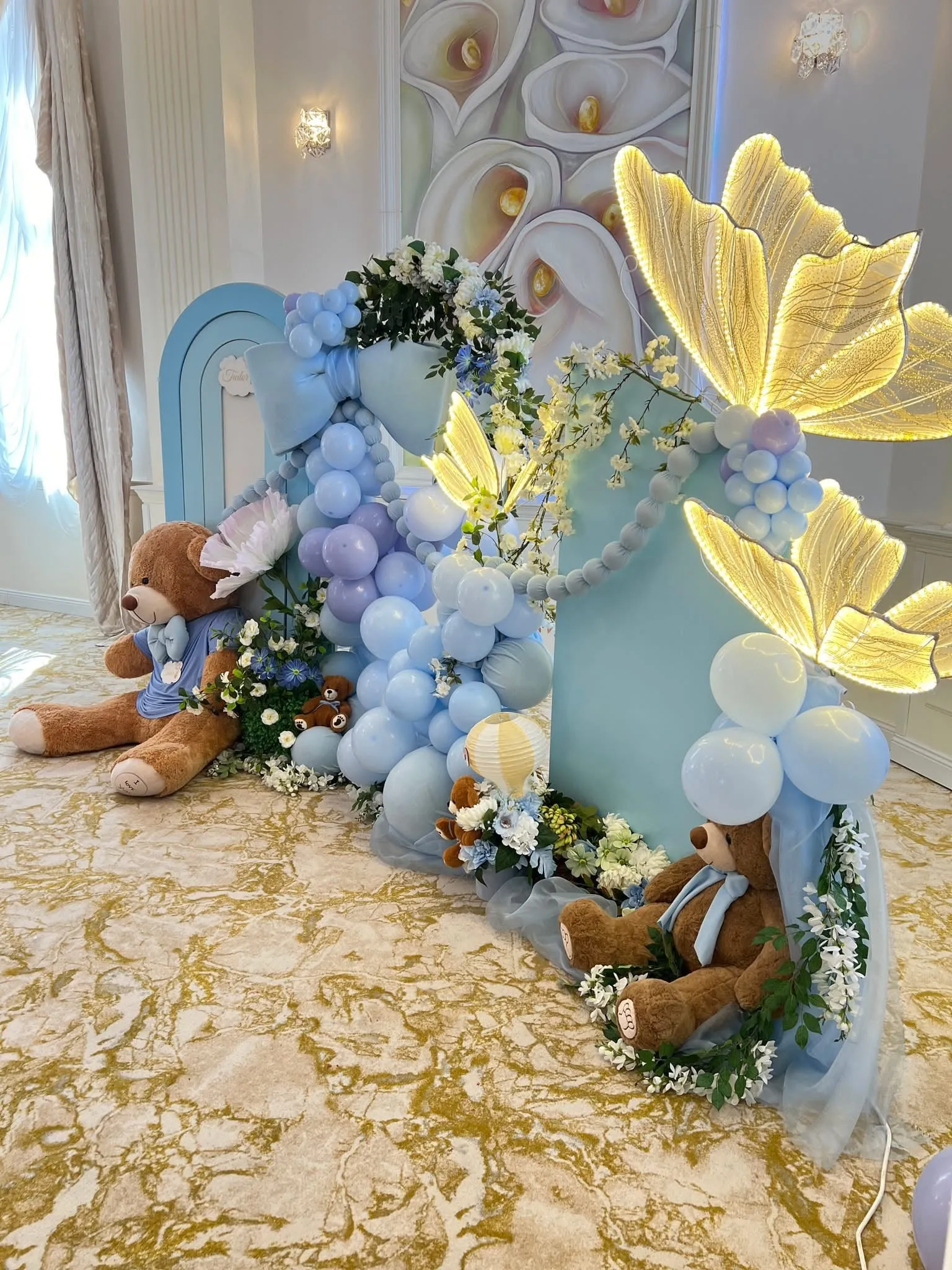 Decor de botez cu baloane albastre, ursuleți de pluș și fluturi luminoși